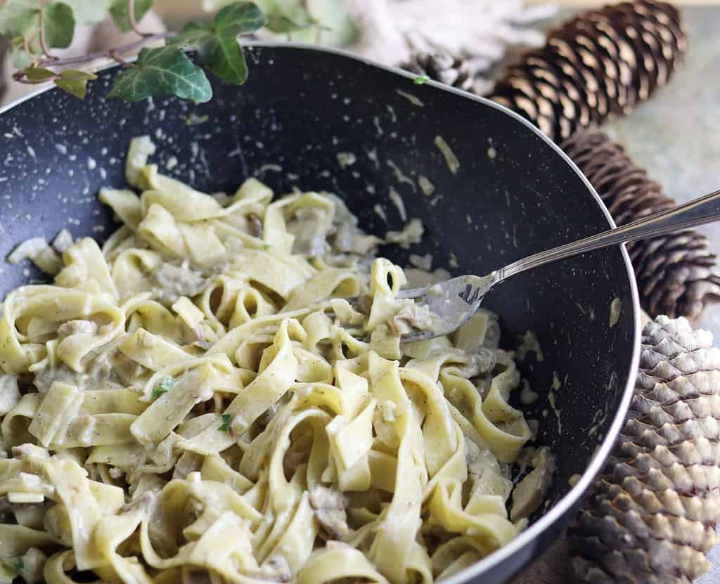 Tagliatelle with porcini mushrooms in an old cooking pan.
